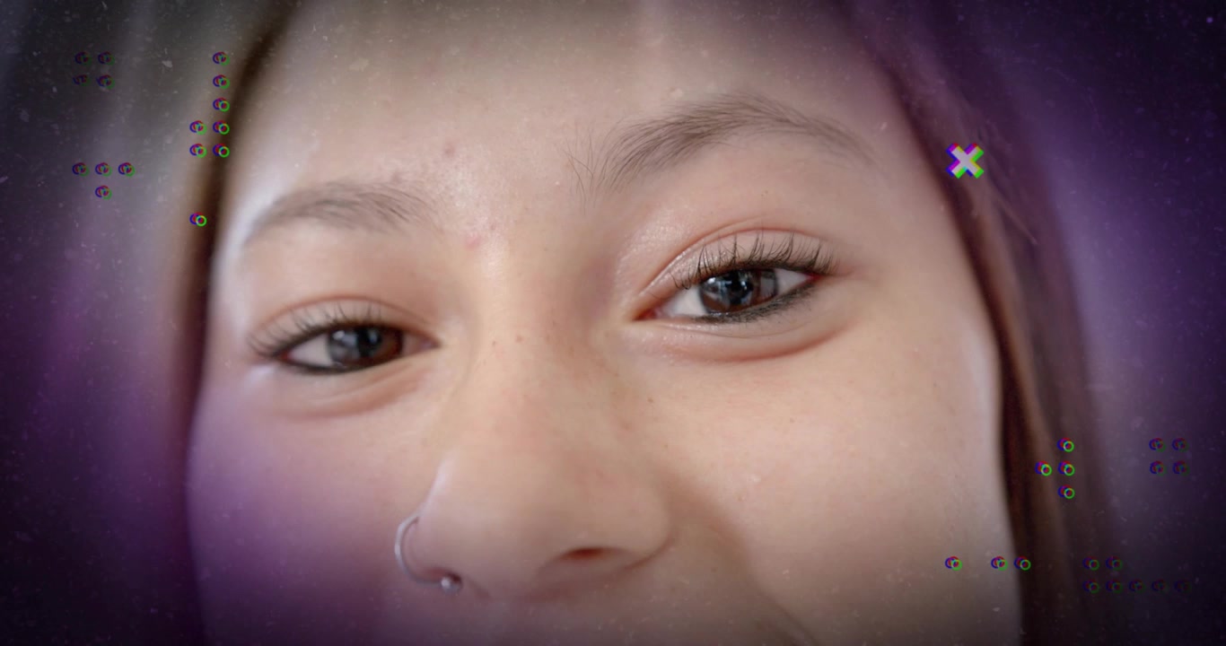Teenage girl gazing at camera, spinner fading in and glitch X shapes drifting in technology demo
