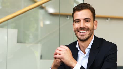 hombre de negocios feliz sentado en las escaleras en la oficina 4k