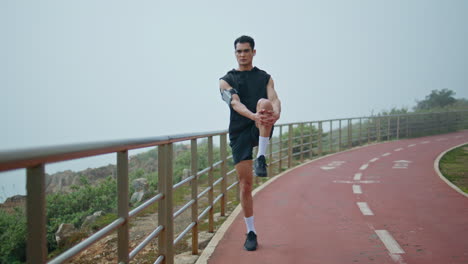 fitness man doing stretching legs before running. professional runner training