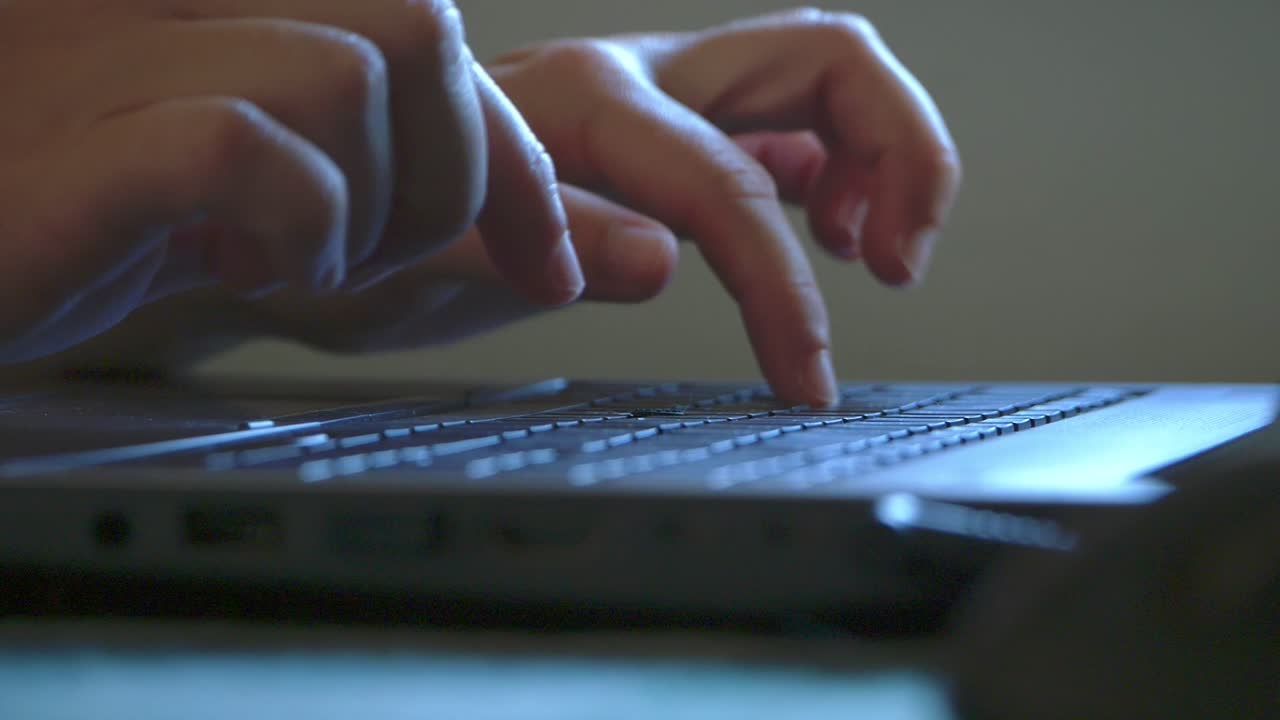 Slow motion shot female hands typing in Laptop keyboard next window