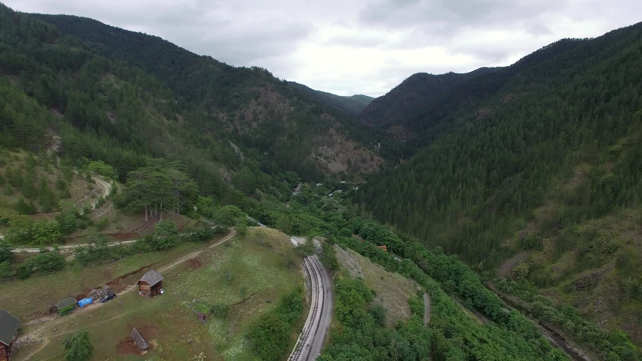 paisaje aéreo de montaña con ferrocarril y pequeño pueblo en serbia