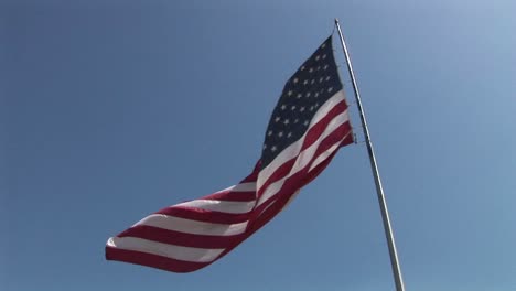 an american flag flies in the wind at day