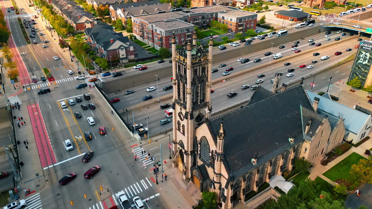 Detroit, USA, 28 July 2025: Approaching the tower of St. John's Episcopal Church in Detroit, Michigan, USA. Heavy traffic on the highways at backdrop