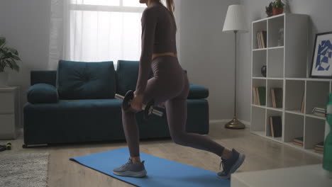 exercises for slender legs and sexy ass woman is squatting with dumbbells at home exercises for keeping fit and losing weight healthy lifestyle and wellness