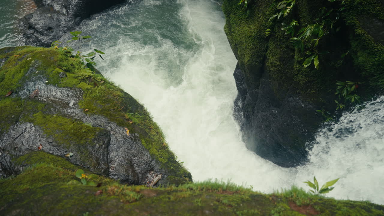Waterfall cascading through mossy rocks in a tropical jungle