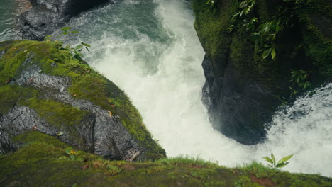 waterfall cascading through mossy rocks in a tropical jungle