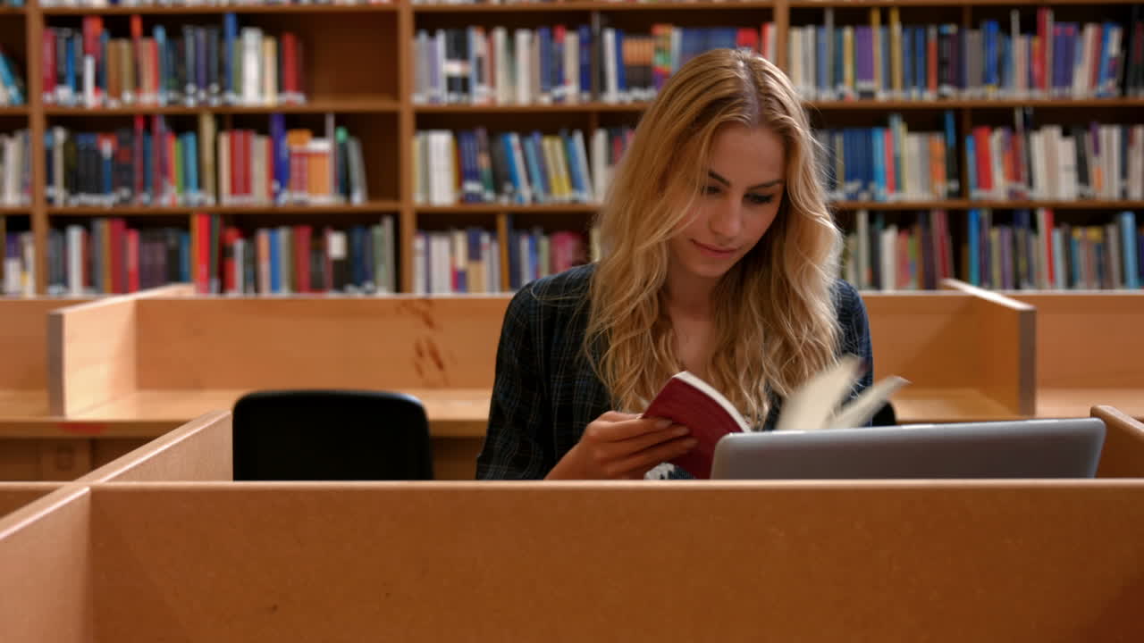 Student jobber på bærbar PC på biblioteket