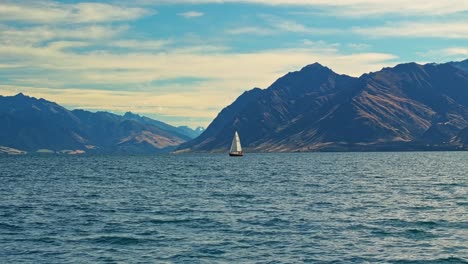 sailboat floats peacefully on calm serene waters of lake hawea
