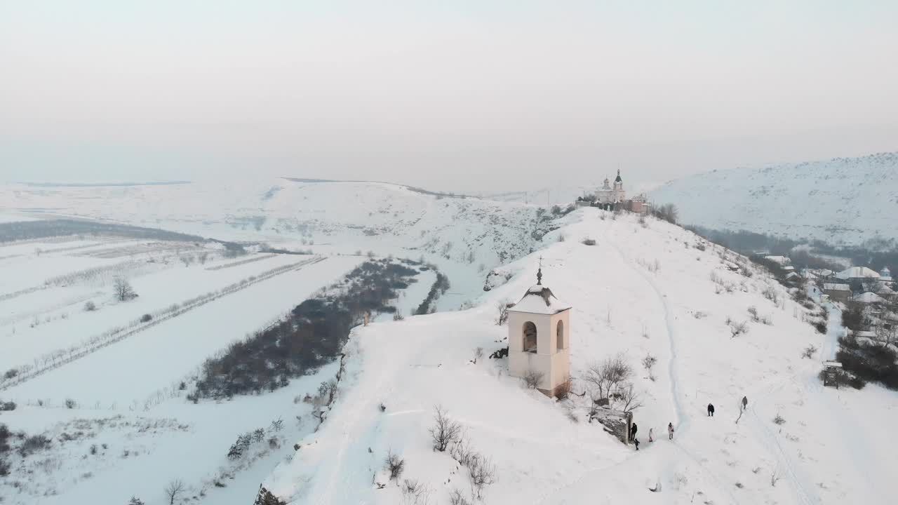 Paesaggio invernale con chiesa su una collina innevata
