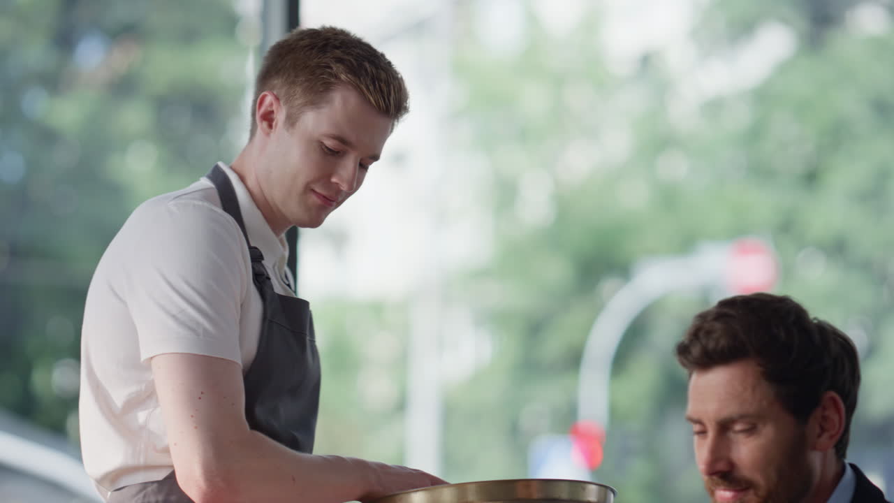 Waiter giving wireless terminal to visitor restaurant closeup. Manager paying
