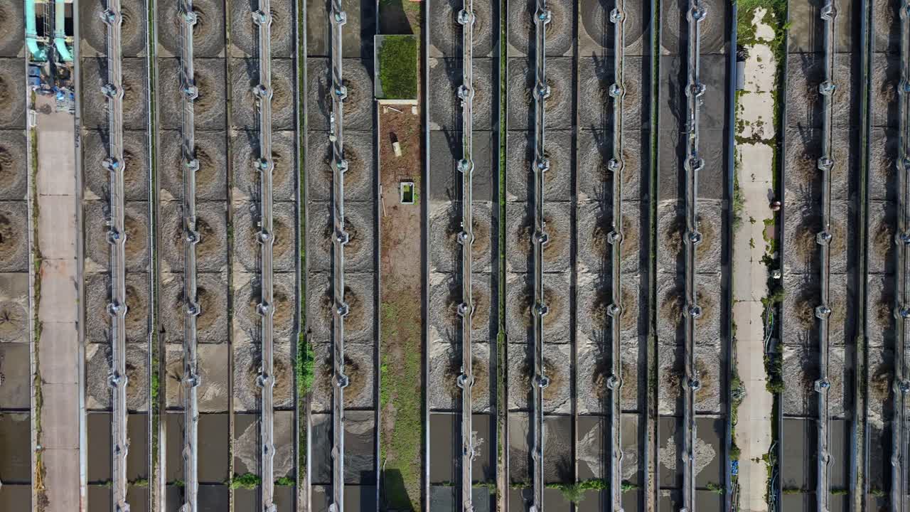 Aerial drone footage of industrial wastewater site near Leicester, UK, with silos and clarifying ponds