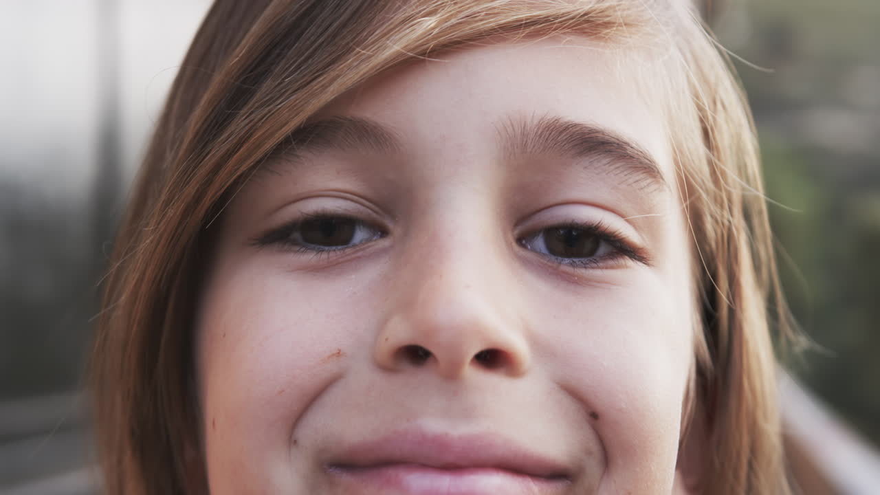 Smiling child with long hair looking at camera, close-up portrait