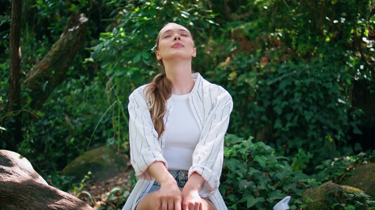 mujer tranquila respirando la naturaleza disfrutando del aire fresco de cerca. mujer sentada en el parque