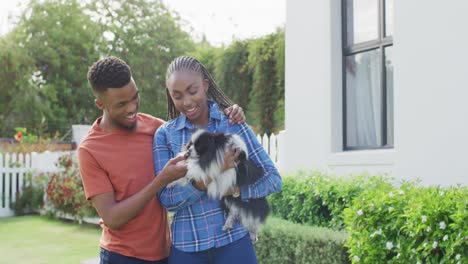 Happy-african-american-couple-with-dog-in-backyard