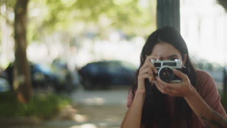 feliz fotógrafa tomando fotos desde diferentes ángulos al aire libre