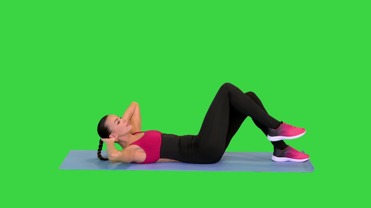 Beautiful attractive girl doing abs exercises on a mat on a Green Screen, Chroma Key