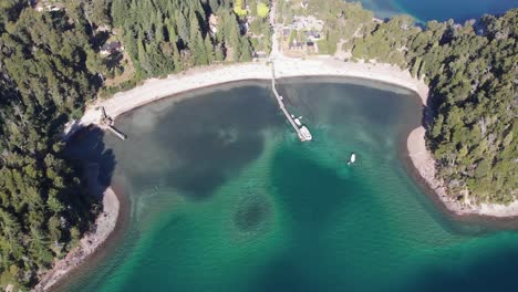 Tilt-down-to-clear-turquoise-water-of-Nahuel-Huapi-Lake-in-Villa-La-Angostura,-Patagonia