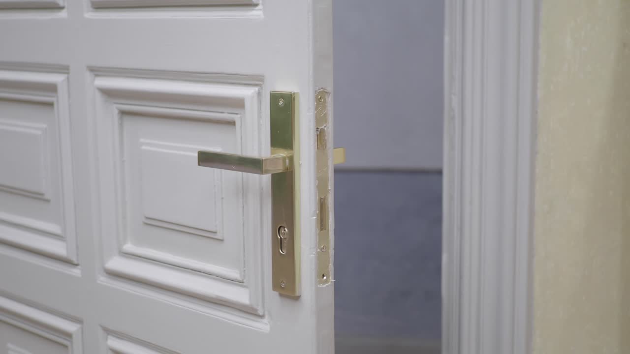 крупный план белой двери с латунной дверной ручкой