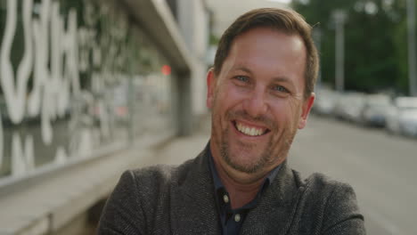 retrato de un hombre de negocios exitoso sonriendo alegremente a la cámara disfrutando del estilo de vida urbano profesional alegre empresario masculino en la calle de la ciudad urbana brazos cruzados