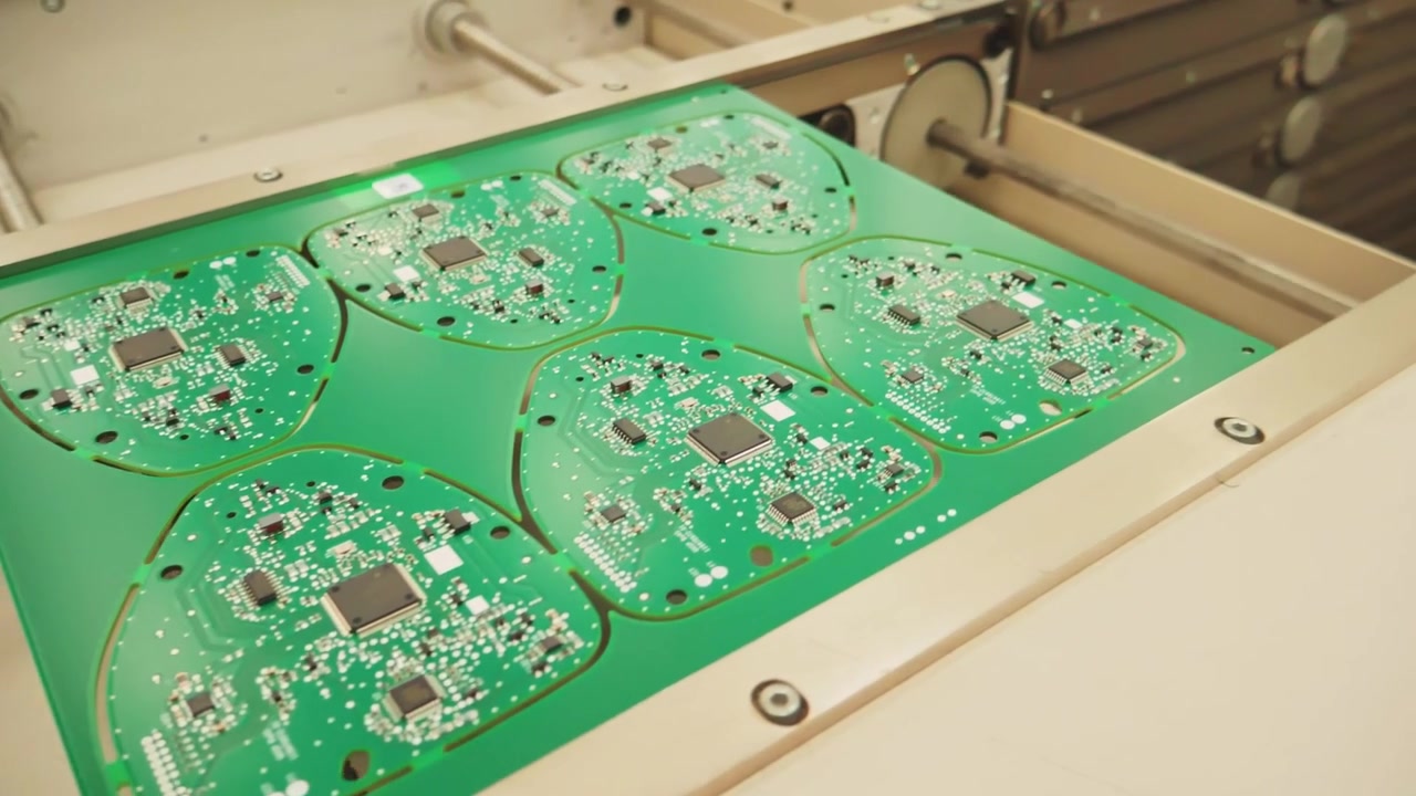 Circuit boards move through machine at technological plant, close view