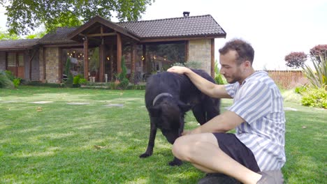 young man loving his dog on the grass.