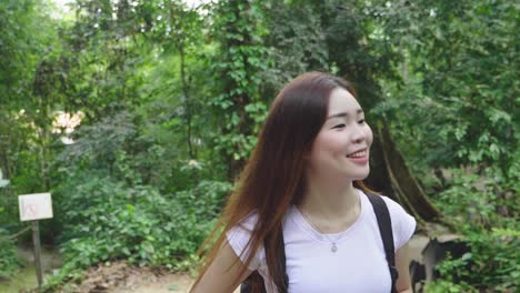 asian girl walking on forest trail, slow motion