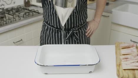 chef pours water into cooking tray