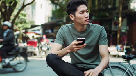 휴대 전화를 사용하는 젊은 베트남 남자의  ⁇ 드헬드 뷰