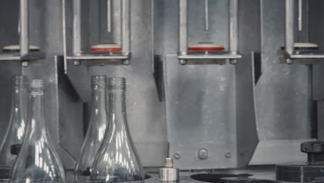 medium shot showing an organized row of glass bottles in a factory, ready to be filled with wine.