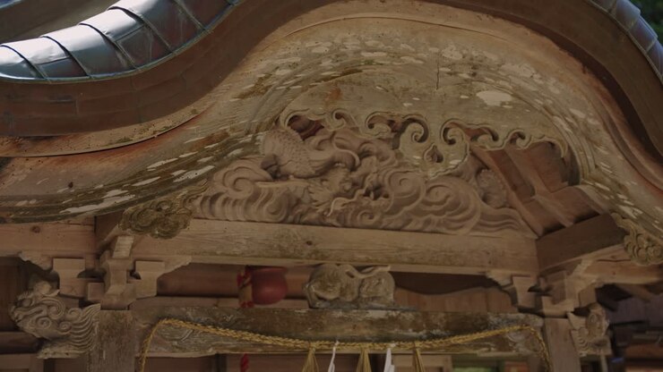 Panoramica ravvicinata su un vecchio arco in legno di un santuario giapponese.