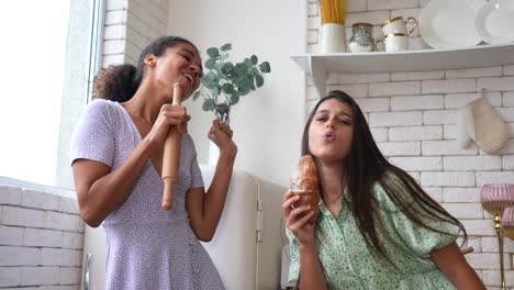 dos amigos cantando y disfrutando de un croissant en la cocina