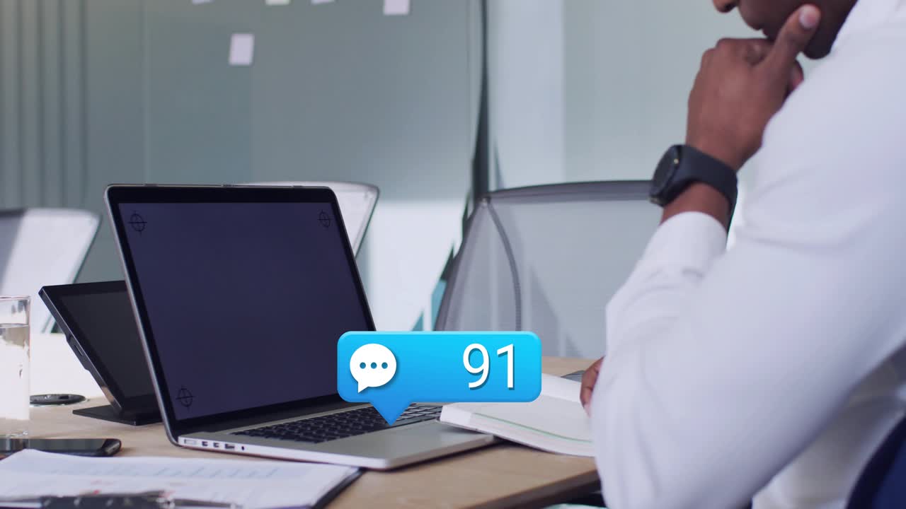 Man watching laptop as new chats arriving, badge rising and bubbles rising, showing office backlog