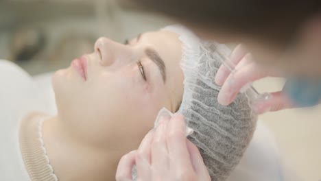 cosmetologist performing facial injection procedure