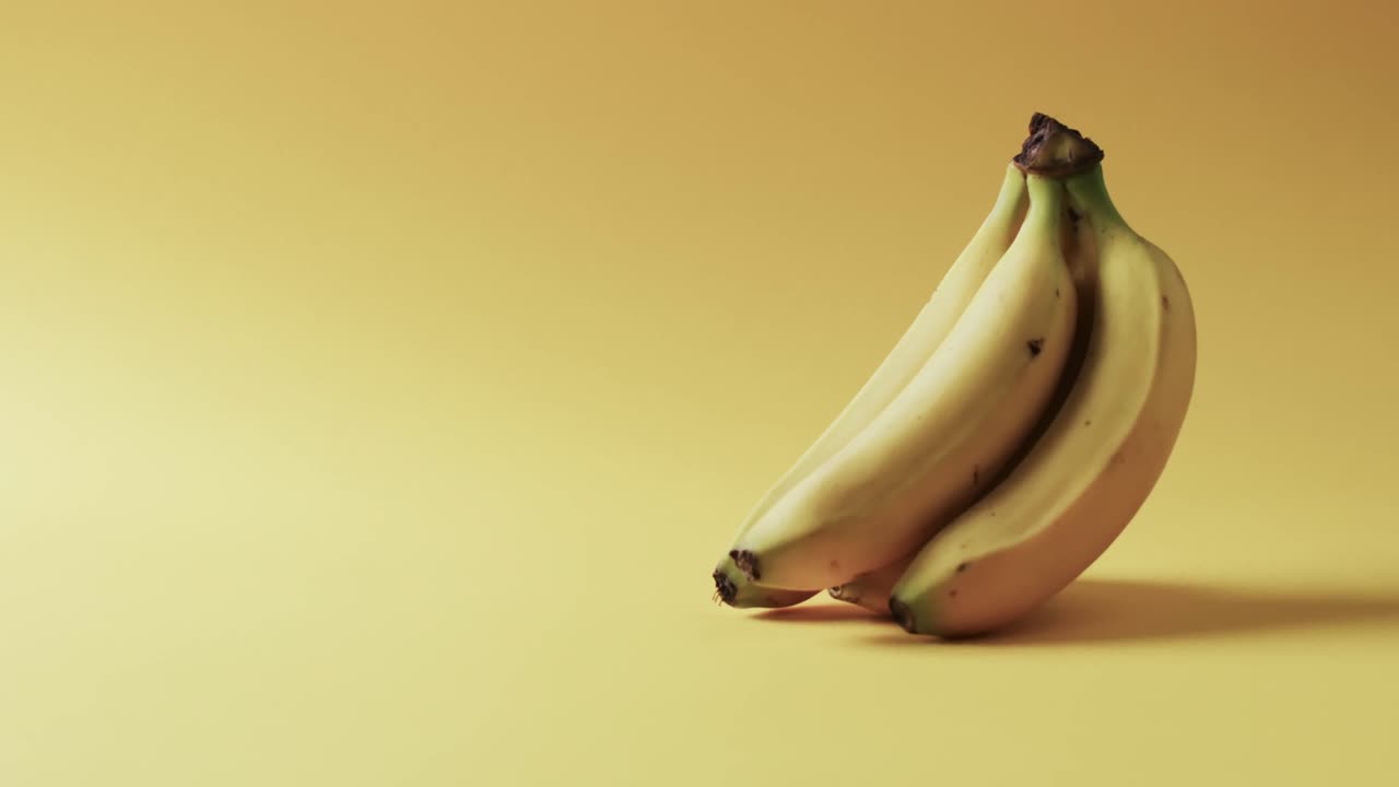 노란색 배경 위에 복사 공간을 가진 바나나의 비디오