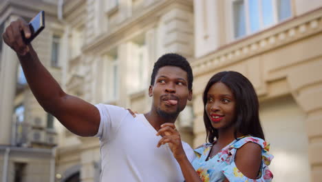 happy afro couple making selfie in old city. african tourists posing on street