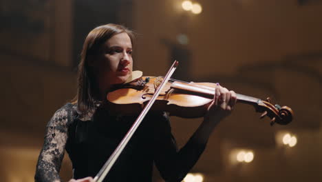 female musician is playing violin on scene of music hall portrait of woman violinist in philharmonic hall