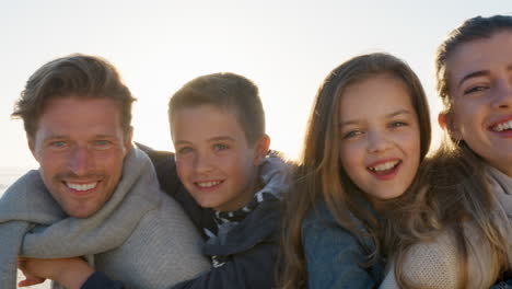 portrait of family walking along winter beach together