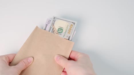 close up of cash money in envelope in hands. money bonus in paper envelope. woman holding envelope with dollar bills.