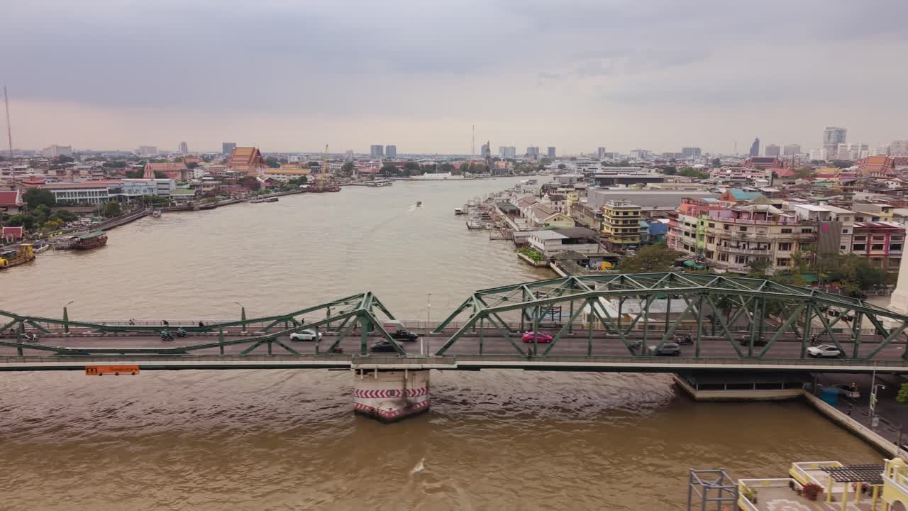 Vista drone del Ponte Phra Pok Klao che attraversa il fiume Chao Phraya a Bangkok, mostrando il flusso di traffico regolare, i battelli fluviali e lo skyline stratificato della capitale della Thailandia. (3)
