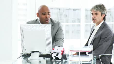 Two-disappointed-businessmen-working-at-a-computer