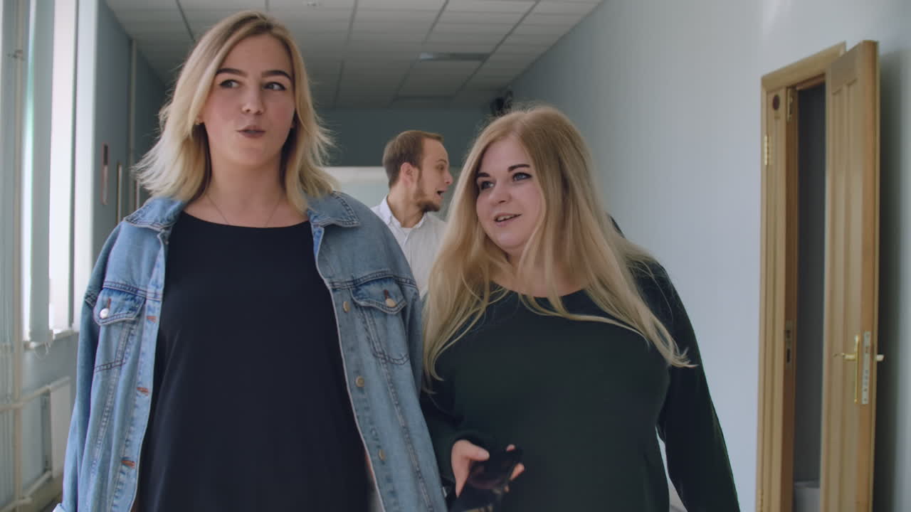 estudiantes multirraciales están caminando en el salón de la universidad durante el descanso y la comunicación