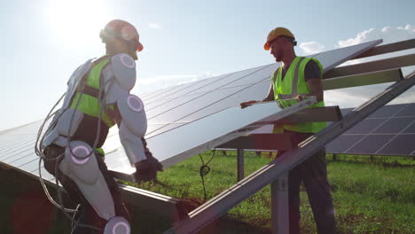 robot and worker installing solar panels