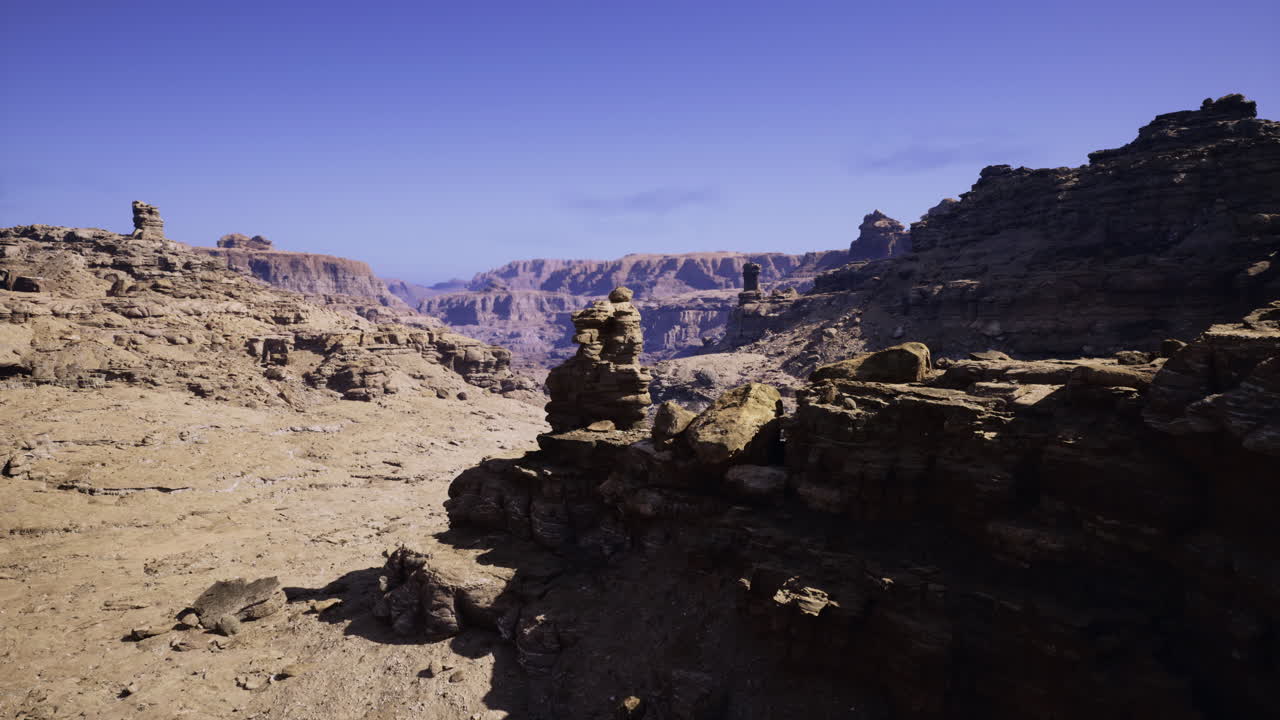 Landscape of rocky terrain and cliffs under a clear blue sky in a desert area