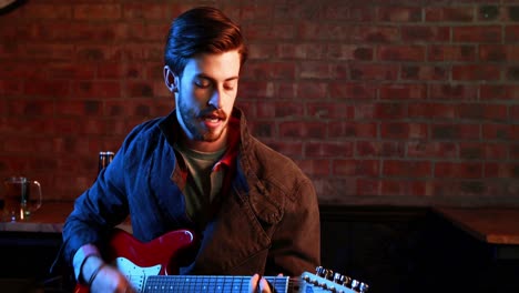 handsome musician singing song while playing guitar