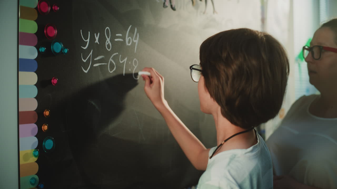 Primary School Student Solving Mathematical Equation Writing on the Board with Chalk