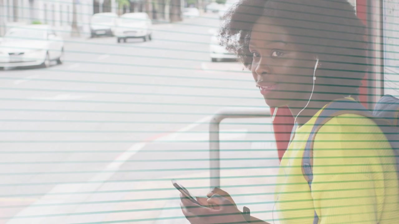 Woman waiting at bus shelter, scrolling phone, tapping screen, lifting head, smiling toward camera