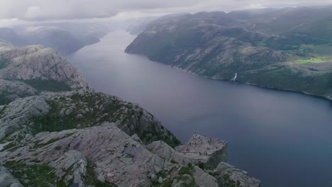 aerial slomo drone shot of preikestolen, norway, with tourists walking and photographing