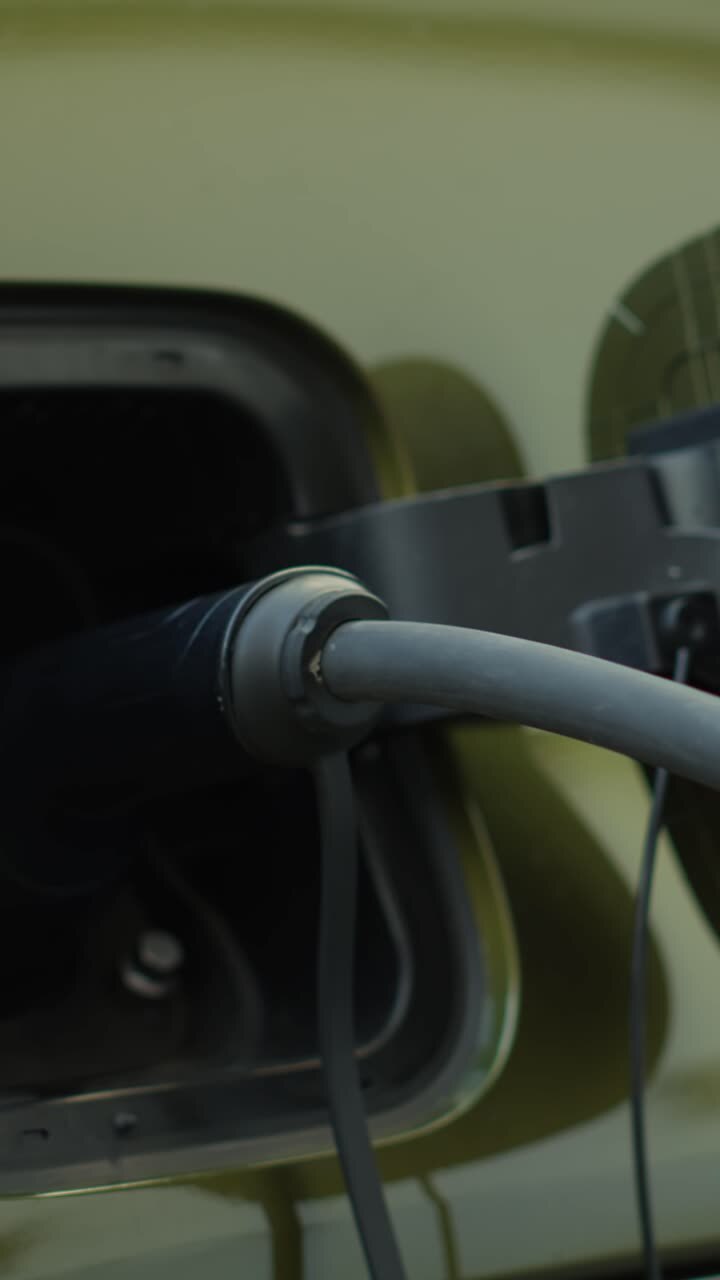 Vertical video Close up shot of driver recharging EV vehicle battery powering electric motor