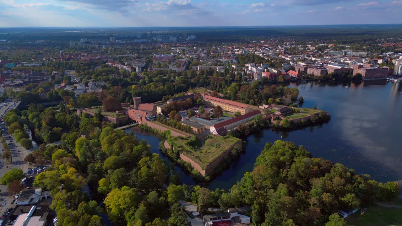 Spandau Citadel, an imposing Renaissance fortress surrounded by water, stands under a clear sky. Gorgeous aerial view flight panorama overview drone