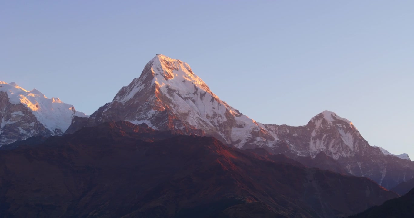 Regione dell'Annapurna, Nepal, ripresa panoramica con drone del Massiccio del Dhaulagiri innevato illuminato dalla calda luce dorata dell'alba.
